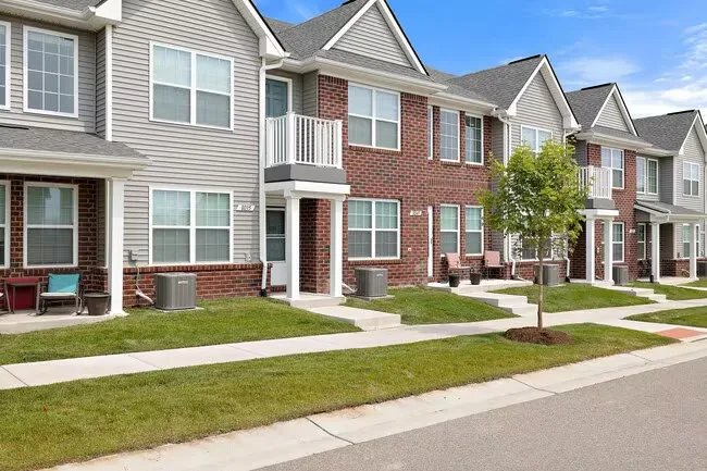 Row of two-story brick and siding townhomes along a quiet residential street
